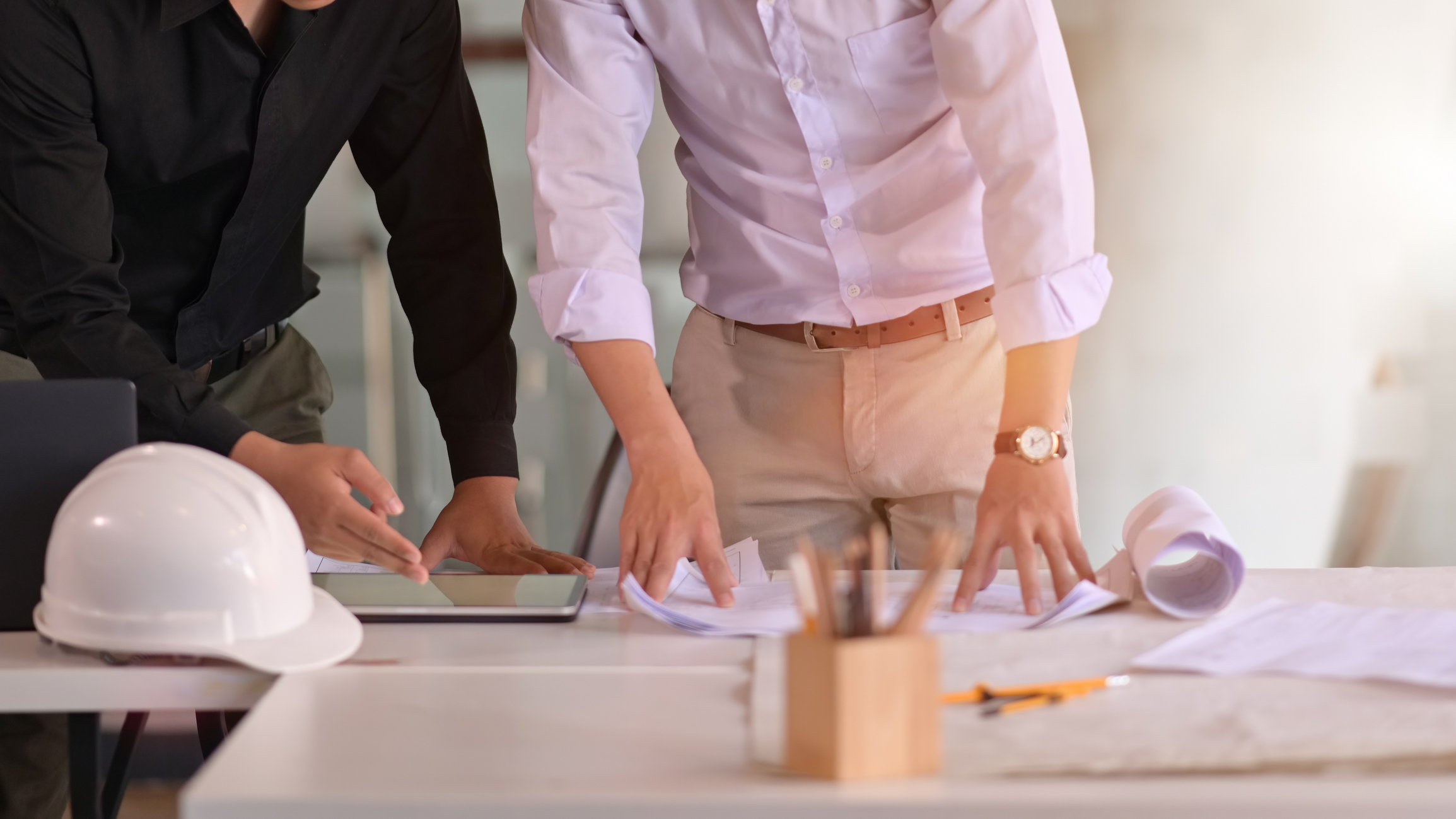 Business people and engineer in a meeting using tablet